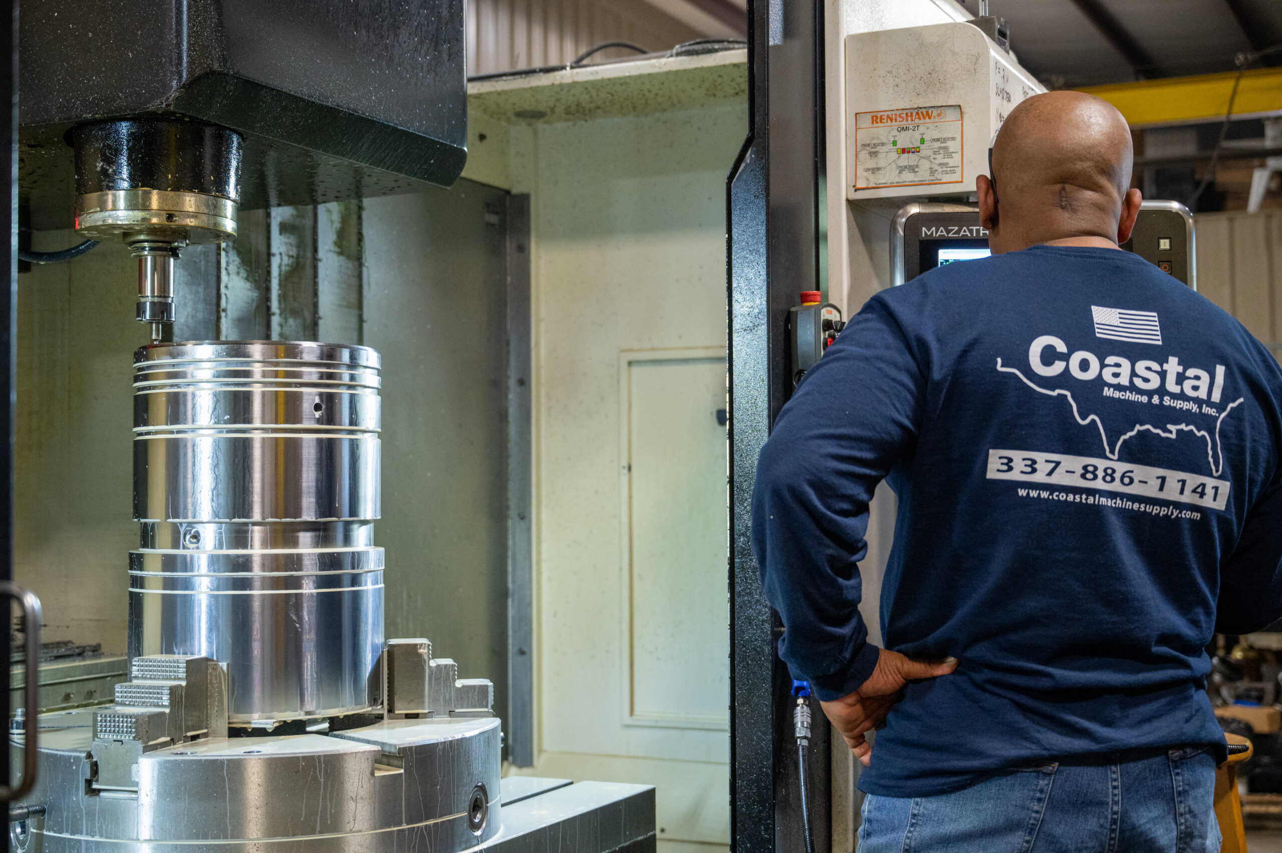 Machinist operating cnc mill designed for large machining capabilities