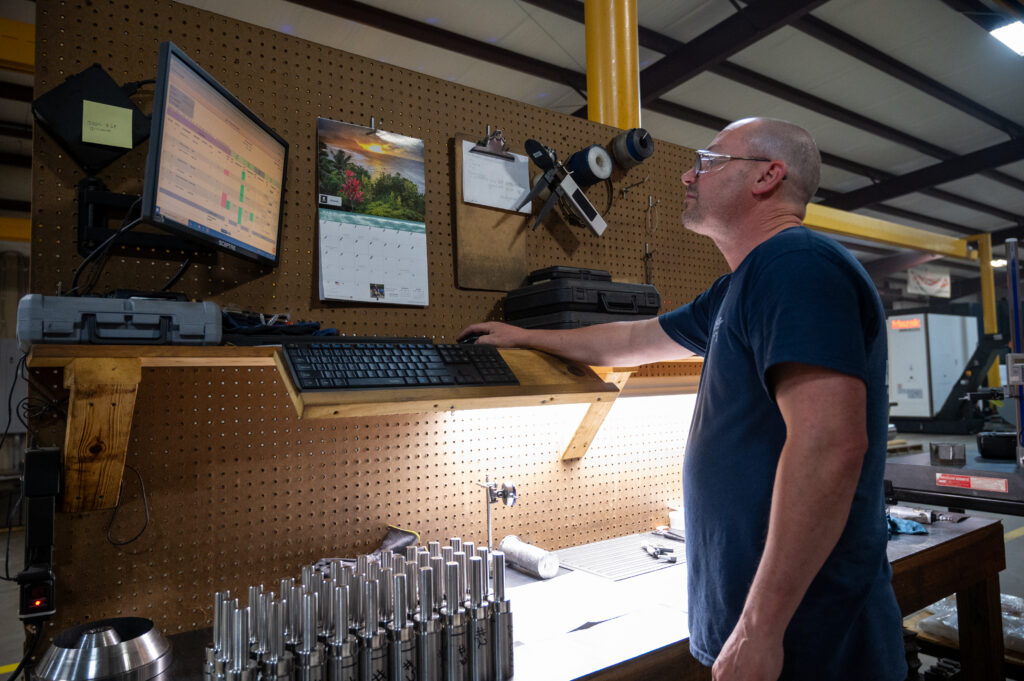 CNC Operator examining machine metrics in Louisiana machine shop