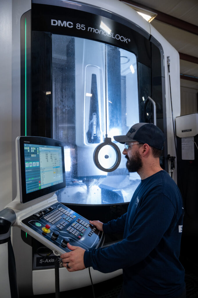 Machinist operating an advanced cnc mill in a machine shop